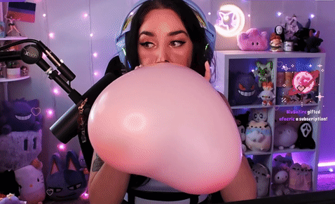 A Woman Is Blowing Up A Pink Balloon In Front Of A Microphone .. GIF