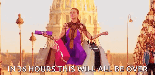 A Woman Is Carrying A Bunch Of Shopping Bags On A Street . GIF