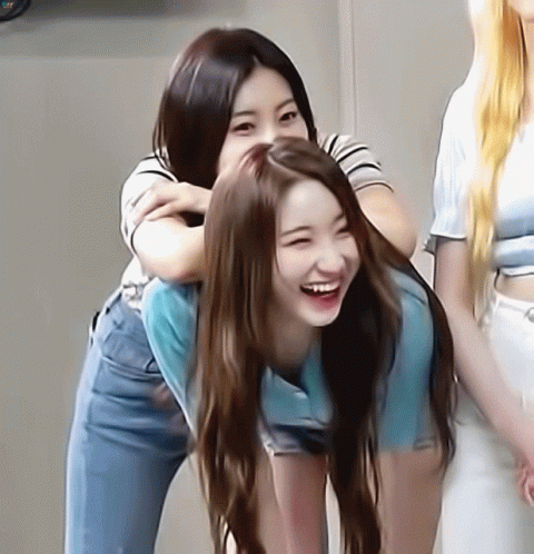 A Woman Is Carrying Another Woman On Her Back And Smiling GIF