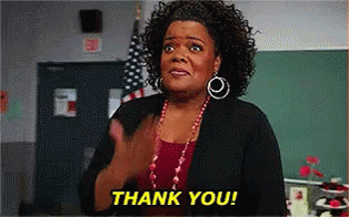 A Woman Is Clapping Her Hands In A Classroom And The Words Thank You Are On The Screen Behind Her . GIF