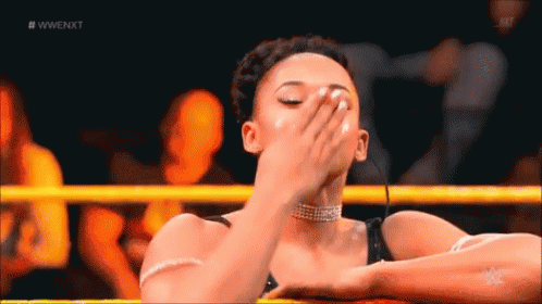 A Woman Is Covering Her Face In A Wrestling Ring . GIF