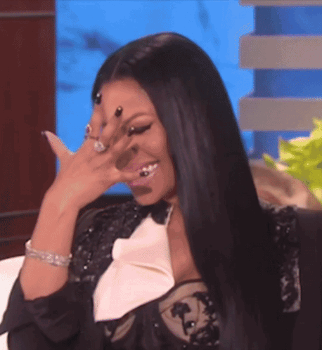 A Woman Is Covering Her Face With Her Hand And Smiling GIF