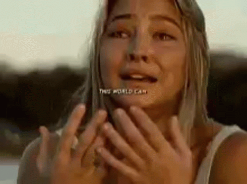 A Woman Is Covering Her Face With Her Hands And Making A Funny Face . GIF