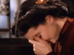 A Woman Is Covering Her Face With Her Hands In A Close Up Of Her Face . GIF