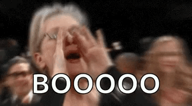 A Woman Is Covering Her Face With Her Hands While A Crowd Of People Applaud . GIF