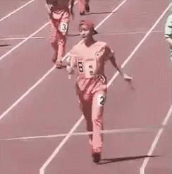 A Woman Is Crossing The Finish Line Of A Track And Field Race . GIF