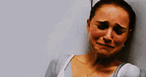 A Woman Is Crying And Leaning Against A Wall With Her Eyes Closed GIF