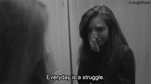 A Woman Is Crying In Front Of A Mirror With The Words " Everyday Is A Struggle " GIF