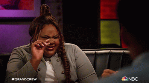 a woman is crying while sitting on a couch with nbc written on the bottom