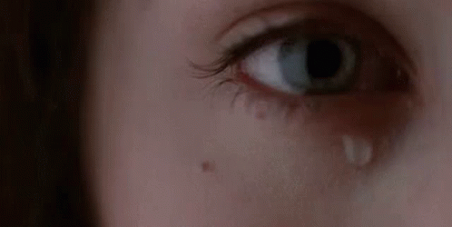 A Woman Is Crying With A Tear Coming Out Of Her Eye . GIF