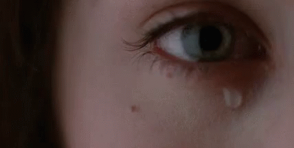 A Woman Is Crying With A Tear Coming Out Of Her Eye . GIF