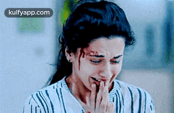 A Woman Is Crying With Blood On Her Face And Covering Her Mouth With Her Hand . GIF