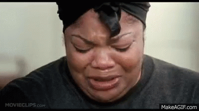 A Woman Is Crying With Her Eyes Closed And Wearing A Black Headband . GIF