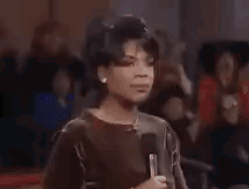 A Woman Is Dancing In A Club With Her Hands In The Air And Her Mouth Open . GIF