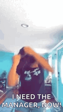 A Woman Is Dancing In A Room And Saying `` I Need The Manager , Now '' . GIF