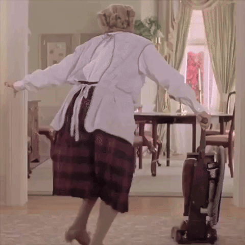 A Woman Is Dancing In A Room With A Vacuum Cleaner GIF