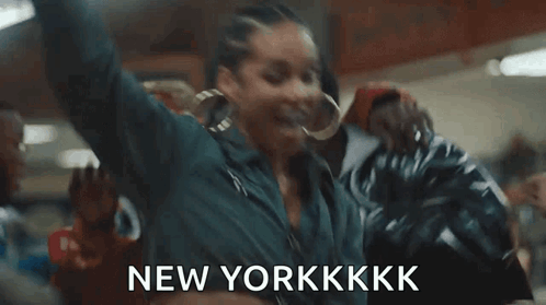 A Woman Is Dancing In A Room With Her Arms In The Air And The Words `` New Yorkkkk '' . GIF