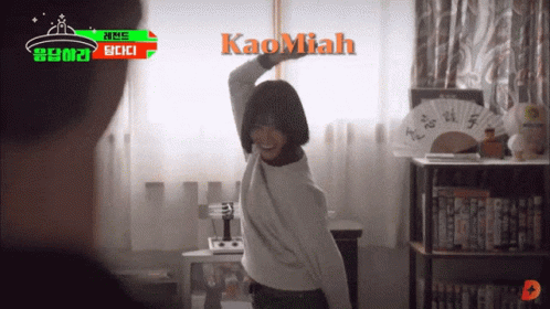 A Woman Is Dancing In A Room With Kaomiah Written On The Wall GIF