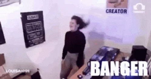 A Woman Is Dancing In A Room With The Words Banger Written On The Wall Behind Her . GIF
