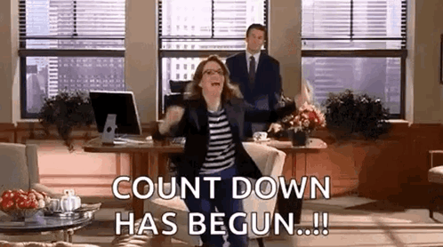 A Woman Is Dancing In An Office While A Man Stands Behind Her And Says `` Count Down Has Begun ! '' GIF