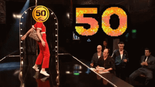 A Woman Is Dancing In Front Of A 50 Sign GIF