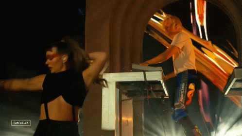 A Woman Is Dancing Next To A Man Playing A Keyboard And The Word Gazelle Is On The Bottom Left GIF