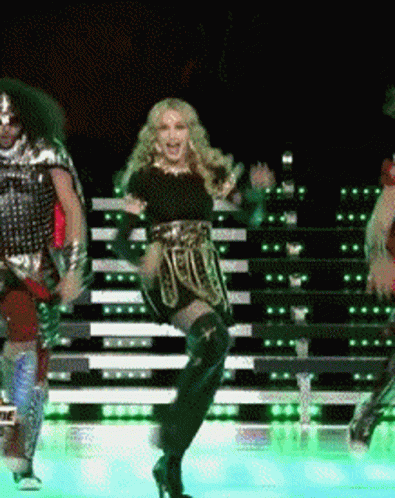 A Woman Is Dancing On A Stage With A Man In Armor GIF