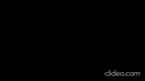 A Woman Is Dancing On A Stage With A Microphone . GIF