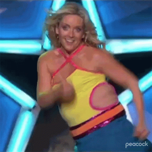 A Woman Is Dancing On A Stage With A Peacock Logo In The Corner . GIF