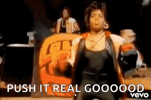 A Woman Is Dancing On A Stage With The Words `` Push It Real Goooood '' . GIF