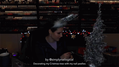 a woman is decorating a christmas tree with her nail peelies