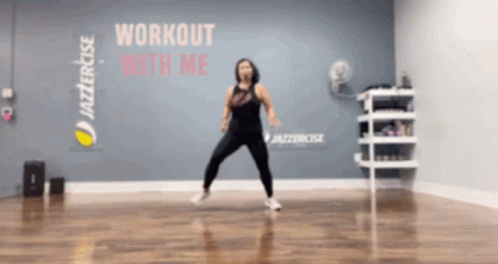 A Woman Is Doing A Workout In Front Of A Wall That Says " Workout With Me " GIF