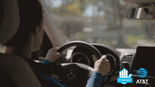 A Woman Is Driving A Mercedes With An At & T Logo On The Dashboard GIF