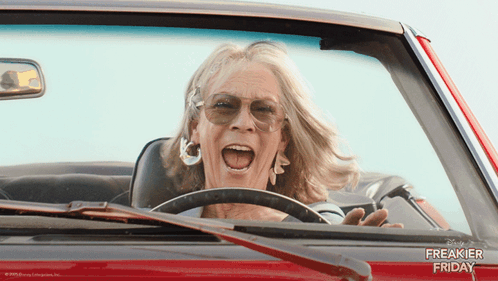 A Woman Is Driving A Red Car With The Words Freakier Friday Written On The Side GIF