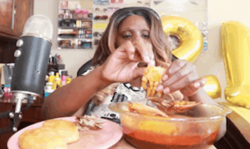 A Woman Is Eating A Bowl Of Food In Front Of A Microphone GIF