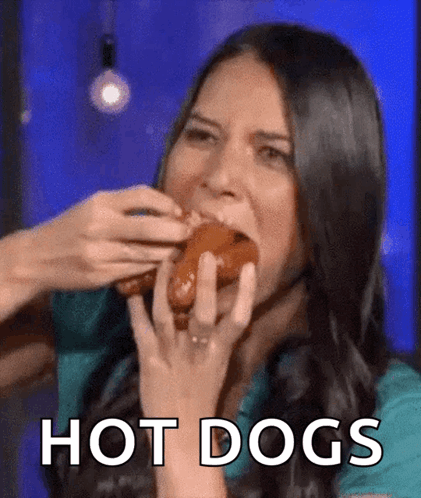 A Woman Is Eating A Hot Dog And The Word Hot Dogs Is On The Bottom GIF