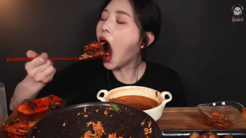 A Woman Is Eating A Meal With Chopsticks And A Bowl Of Soup GIF