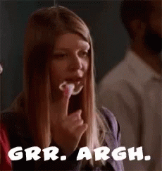 A Woman Is Eating A Piece Of Food And The Words Grrr Argh Are On The Bottom Of The Picture . GIF