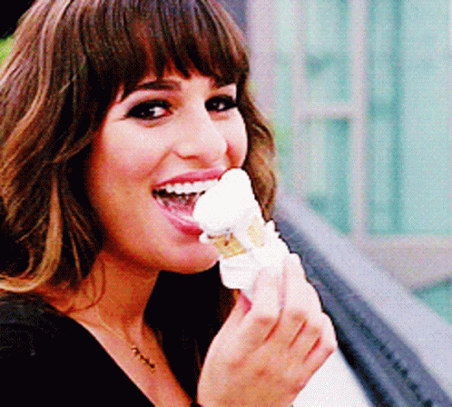 A Woman Is Eating An Ice Cream Cone With Her Tongue Hanging Out GIF