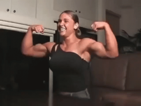 Woman Flexing Muscles And Smiling GIF