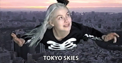 A Woman Is Flying Through The Air In A Tokyo Skies Shirt . GIF
