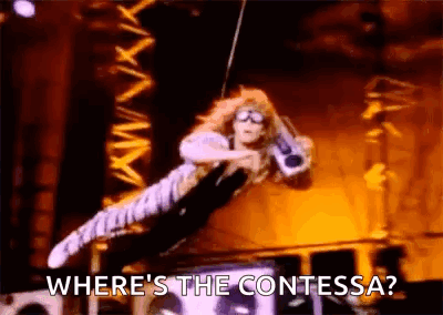 A Woman Is Flying Through The Air While Holding A Microphone And Says `` Where 'S The Contessa ? '' GIF