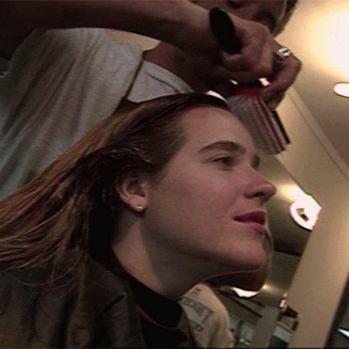 A Woman Is Getting Her Hair Brushed By A Hairdresser GIF