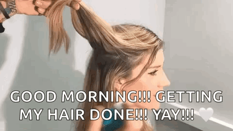 A Woman Is Getting Her Hair Done By A Hairdresser In A Room . GIF