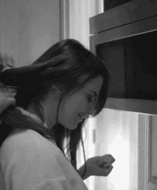 A Woman Is Getting Her Hair Done In A Black And White Photo GIF