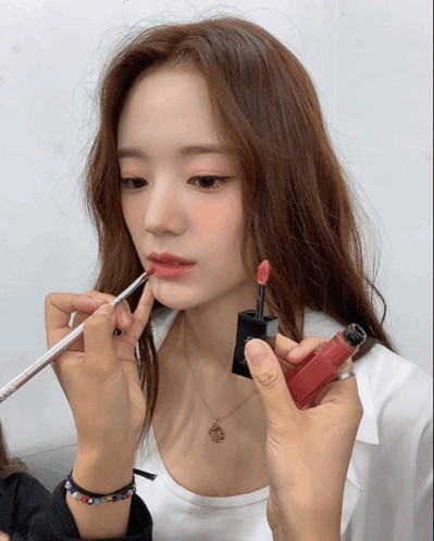 A Woman Is Getting Her Lips Painted With A Red Lipstick GIF