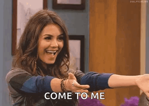 A Woman Is Giving A Thumbs Up And Smiling While Holding Out Her Arms And Saying Come To Me . GIF