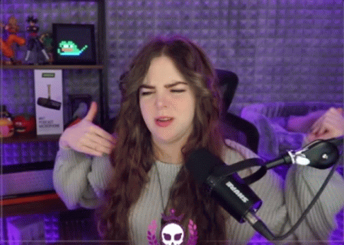 a woman is giving a thumbs up in front of a microphone that says shure