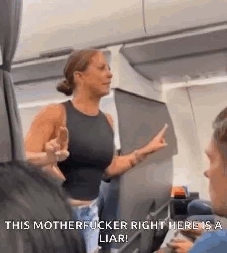 A Woman Is Giving The Middle Finger On An Airplane While Talking To A Man . GIF