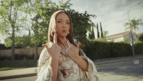 A Woman Is Giving The Middle Finger While Standing On The Sidewalk GIF